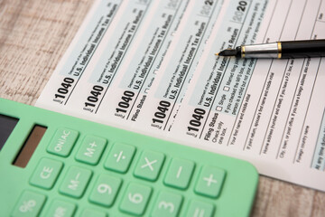Fototapeta premium paperwork 1040 individual income tax form document with pen and calculator