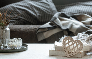 Cozy home composition with decorative wooden heart and books and decor details.