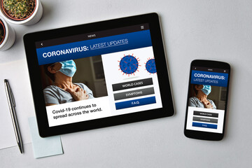Coronavirus latest news concept on tablet and smartphone screen over gray table. Flat lay