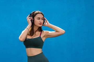 Happy fitness woman in sportear listening to music isolated