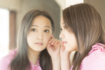 Obraz na płótnie Canvas 見つめる　若い女性　鏡