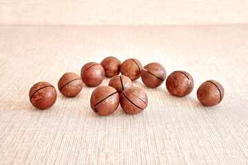 Macadamia nuts are laid out in the shape of an arrow on a horizontal surface.