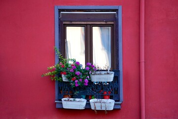 Fototapeta na wymiar window on the red facade of the house, bilbao city architecture