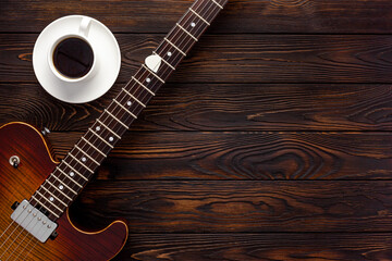 Beautiful electric guitar on with headphones and coffee desktop