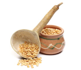 Yellow split peas pile with calabash gourd half and clay bowl isolated on white background