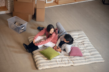 Lying down. New property owners, young couple moving to new home, apartment, look happy. Dream,...