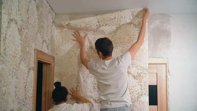 A man holds a wali in his hands and covers the putty wall with glue