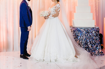 Fototapeta premium Bride and groom in a romantic moment edding ceremony. Cute young married couple.