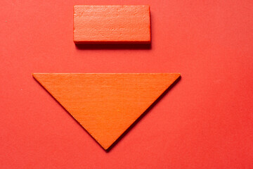 An orange down arrow on a red background
