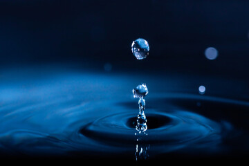 Fototapeta na wymiar abstract background of blue water splash falling drop on liquid wave