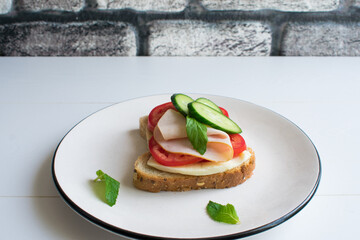 Delicious sandwich with ham, tomato, cucumber, cheese and mint.