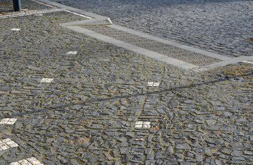 mosaic of small marble cubes. sidewalks and squares formed by stone carpet with squares, polka dots...