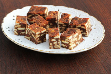 Lazy cake or mosaic cake . Homemade no bake chocolate biscuit cake on a wooden table