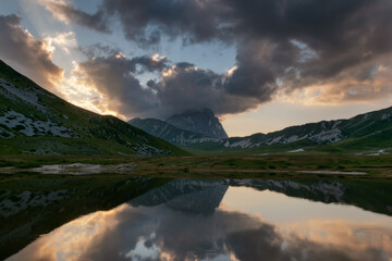 Fototapeta na wymiar Lake with mountain reflection and clouds.