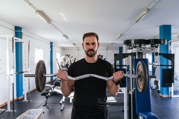 Man making biceps with bar and weights. Concept of health and wellbeing