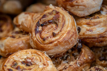 Small Danish pastries with raisins, chocolate chips, and vanilla cream, sold in a sweets store