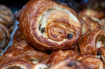 Small Danish pastries with raisins, chocolate chips, and vanilla cream, sold in a sweets store