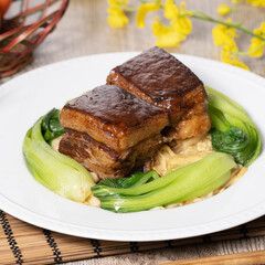 Dong Po Pork meat in a blue plate with broccoli with red background.