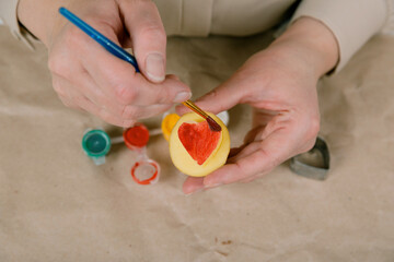heart shaped potato stamp on craft paper. The process of decorating a gift for Valentine's Day. Getting ready for the celebration on February 14th.