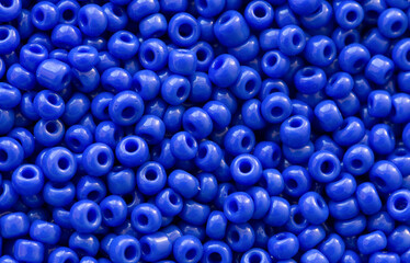 Background texture of Royal blue color beads closeup. Seamless beads texture. Hobbies, handmade jewelry, craft. Abstract background