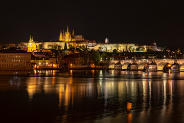 Fototapeta na wymiar View of the city of Prague with St. Vitus Cathedral on the hill, Charles Bridge and the Vltava river at night