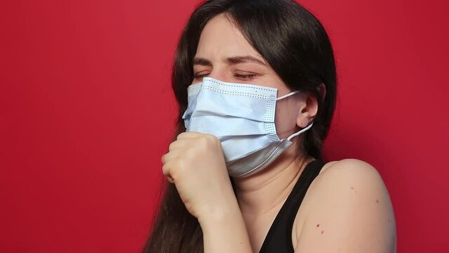 Sick woman coughs heavily, hemoptysis hemorrhage spitting blood in saliva as a result of tuberculosis or lung cancer on a red background. Open tuberculosis or severe pneumonia lung disease