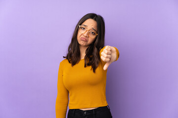Young mixed race woman isolated on purple background showing thumb down with negative expression
