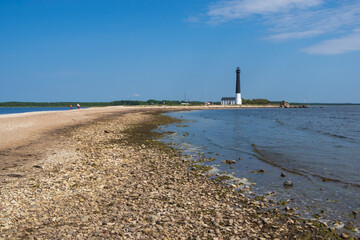 Fototapeta premium View to the beach of Sõrve peninsula cape with sand and pebbles by coastline. Lighthouse in the background. 