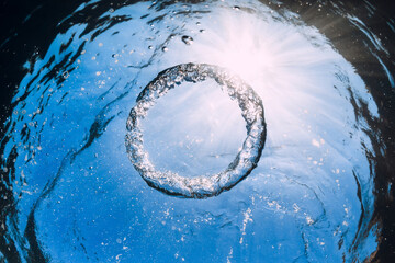 Ring bubble underwater and sun in blue ocean.
