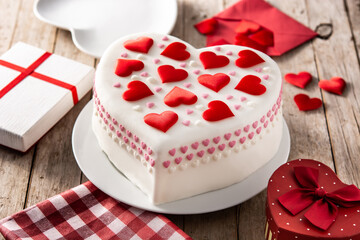 Heart cake for St. Valentine's Day, Mother's Day, or Birthday, decorated with sugar hearts on wooden table	
