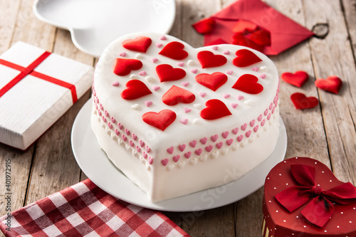 Heart cake for St. Valentine's Day, Mother's Day, or Birthday, decorated with sugar hearts on wooden table