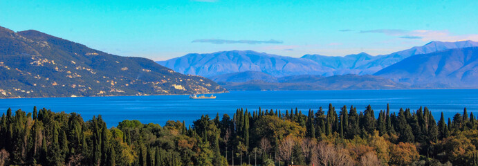 panoramic view of corfu island, mountains and sea with cypress and olive trees
