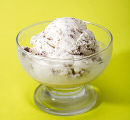 Ice cream cookies and cream in a bowl on a yellow background. Seletive focus