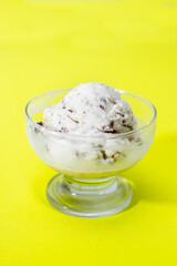 Ice cream cookies and cream in a bowl on a yellow background. Seletive focus