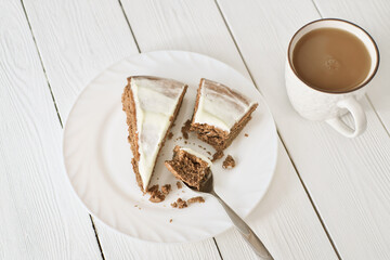 Selected focus top view at a cup of flat white coffee and chocolate pie on white plate on a white table. homemade cake with frosting and a cup of coffee. good morning concept.