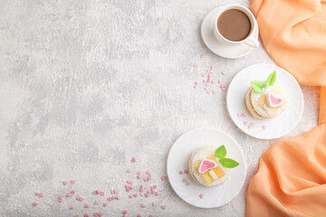 Decorated cake with milk and coconut cream with cup of coffee on a gray concrete background. top...