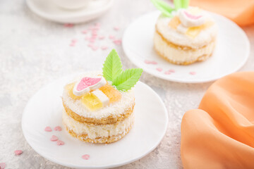Decorated cake with milk and coconut cream with cup of coffee on a gray concrete background. Side view, selective focus.