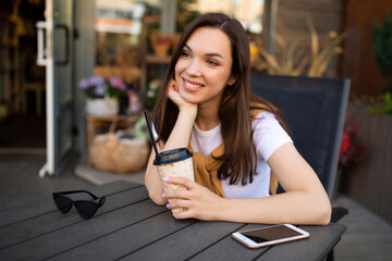 attractive young woman drinking coffee on lunch break outdoors