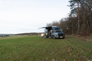 Frau sitzt vor einem Wohnmobil. Camping. L&uuml;tzelsoon, Soonwald-Nahe, Rheinland-Pfalz, Deutschland