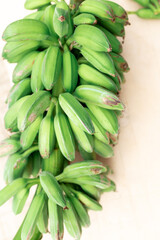 Fototapeta premium cut Green bananas ripen on a branch. Organic bananas grow on the banana tree.