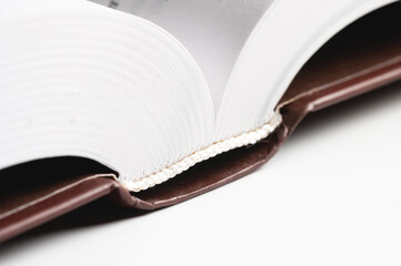 Close-up of the hardback of a thick book on a gray background. Reading and libraries
