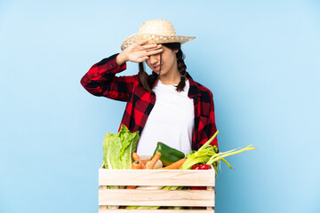 Young farmer Woman holding fresh vegetables in a wooden basket with tired and sick expression