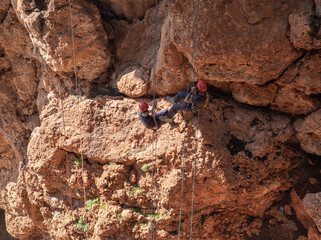 Two athletes make the descent on a rope down - climbing - snapping - the rope from the mountain to Keshet, Cave in northern Israel.