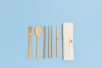 Set of bamboo cutlery with a case on a blue background. Zero waste concept.