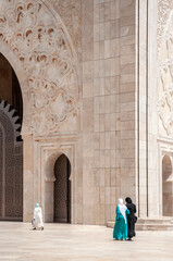 Mosque and women - Casablanca, Morocco. Traditional arabic arch and decorated ceiling of the mosque with women going to prayer.