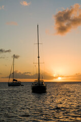 Anchoring ships in tropical bay at sunset. Small yachts and catamarans on sea water during dusk. Santa Lucia. Caribbean lifestyle themes
