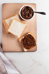 Sandwich with chocolate butter on wooden background. Breakfast with coffee 