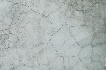 Cracked cement texture in light grey earth tone for background. Close up image of raw grunge surface material.