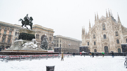 Fototapeta premium The famous statue in the middle of the cathedral square in Milan (Italy) under a heavy snowfall