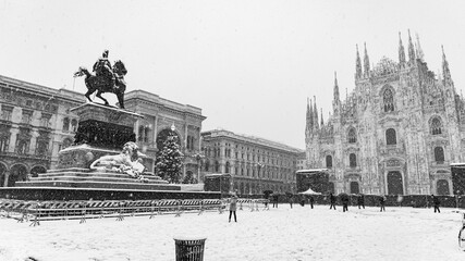 The famous statue in the middle of the cathedral square in Milan (Italy) under a heavy snowfall. Monochromatic.